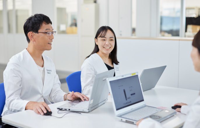 写真：パソコンを操作しながら、金子翔太さんと白衣を着た女性が話している様子