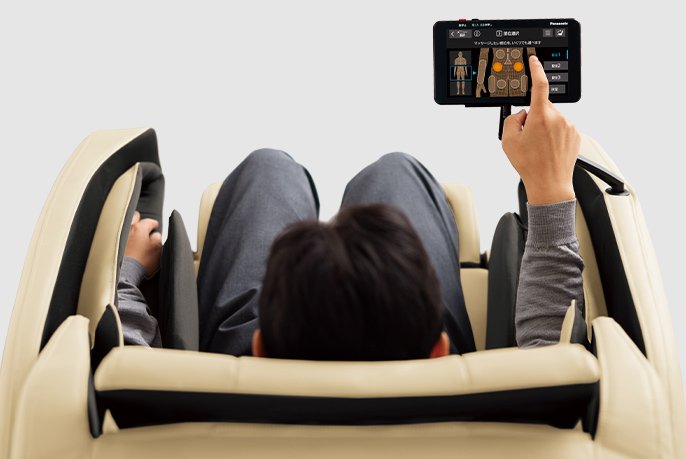 写真：リアルプロに座ってタッチパネルの画面に触れてるイメージ