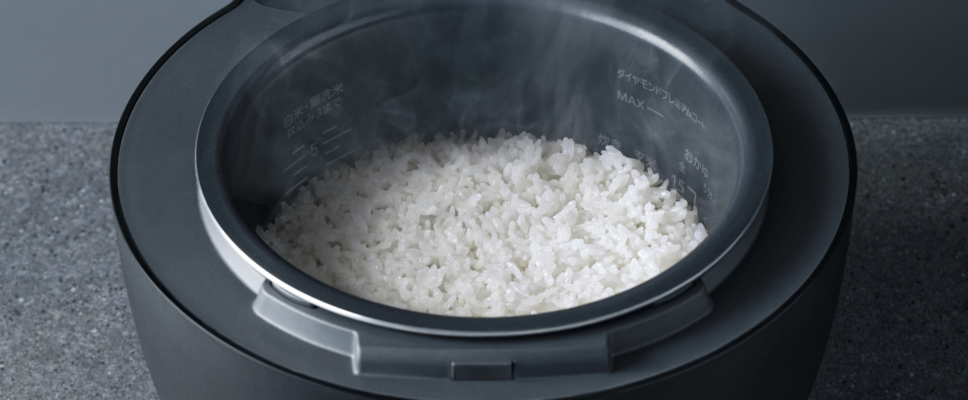 お米が炊きあがり、炊飯器の蓋を開けている画像です。