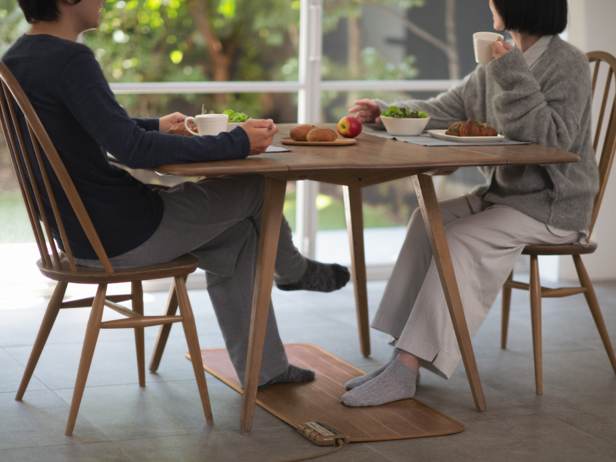 テーブルの下にホットパネルを敷いて使用するイメージ