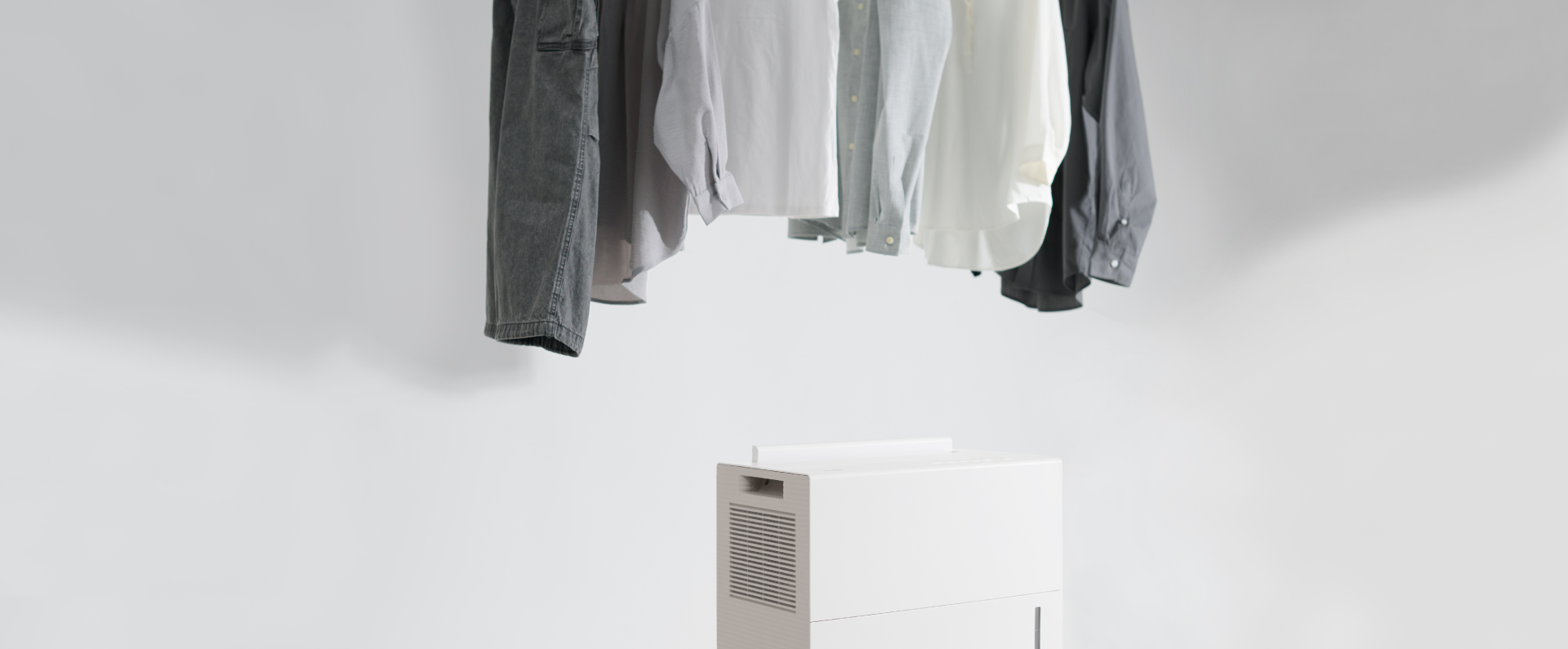 除湿機のツインルーバーがスイングし、 洗濯物と洗濯物の間に風を送っている画像です