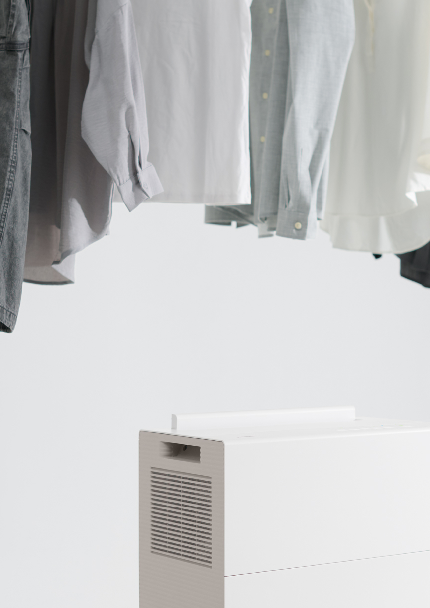 除湿機のツインルーバーがスイングし、 洗濯物と洗濯物の間に風を送っている画像です