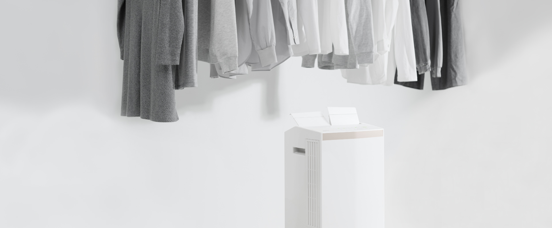 除湿機のツインルーバーがスイングし、 洗濯物と洗濯物の間に風を送っている画像です