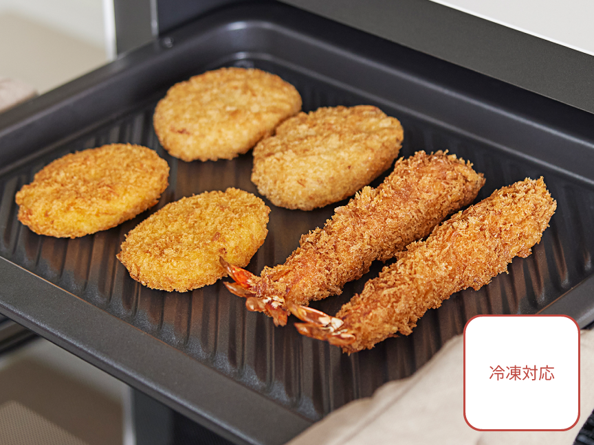画像：あたため直した市販の冷凍フライ食品を取り出す様子。