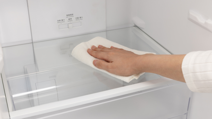 画像：ガラス棚を布巾で拭いているイメージ