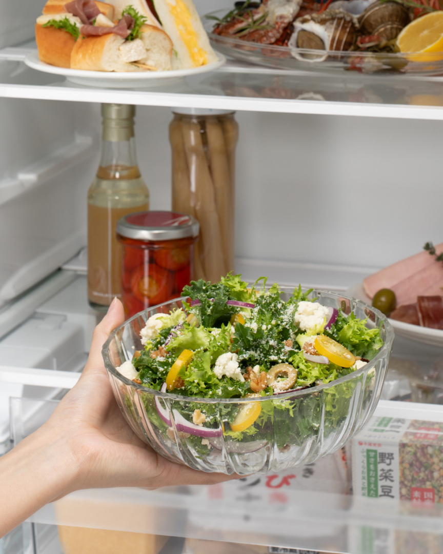 器に入れたサラダをラップなしで冷蔵庫に入れようとするイメージ