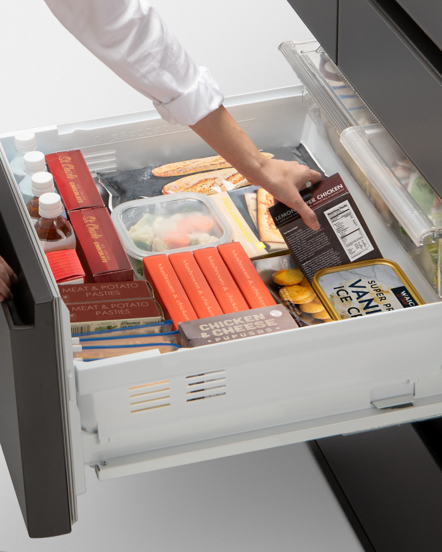 画像：冷凍室を全開まで引き出して食品を取り出しているイメージ