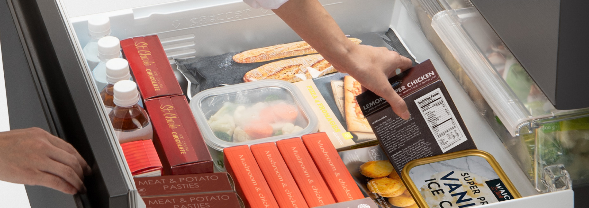 画像：冷凍室を全開まで引き出して食品を取り出しているイメージ