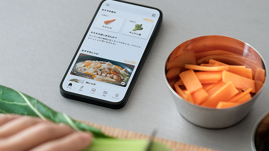 画像：スマホを見ながら調理しているイメージ