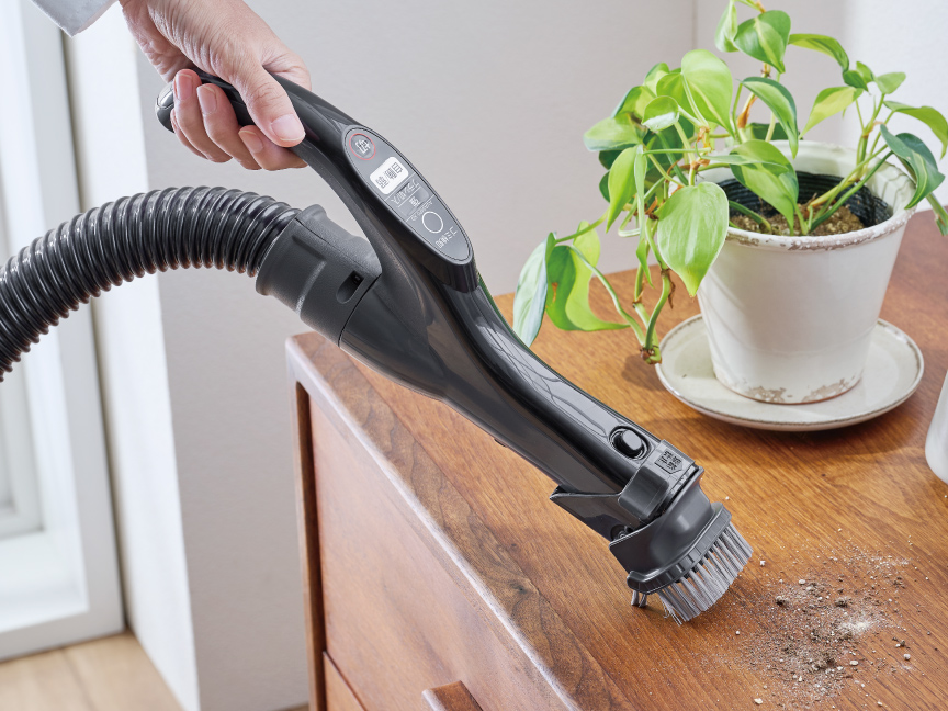 写真：ワンタッチ手元ブラシで棚上を掃除する様子