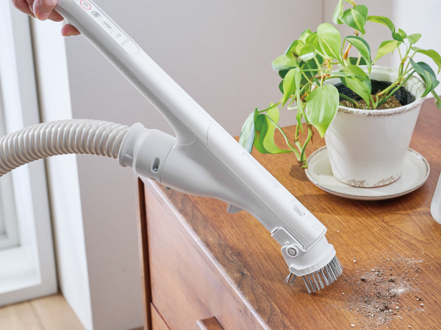 写真：ワンタッチ手元ブラシで棚上を掃除する様子