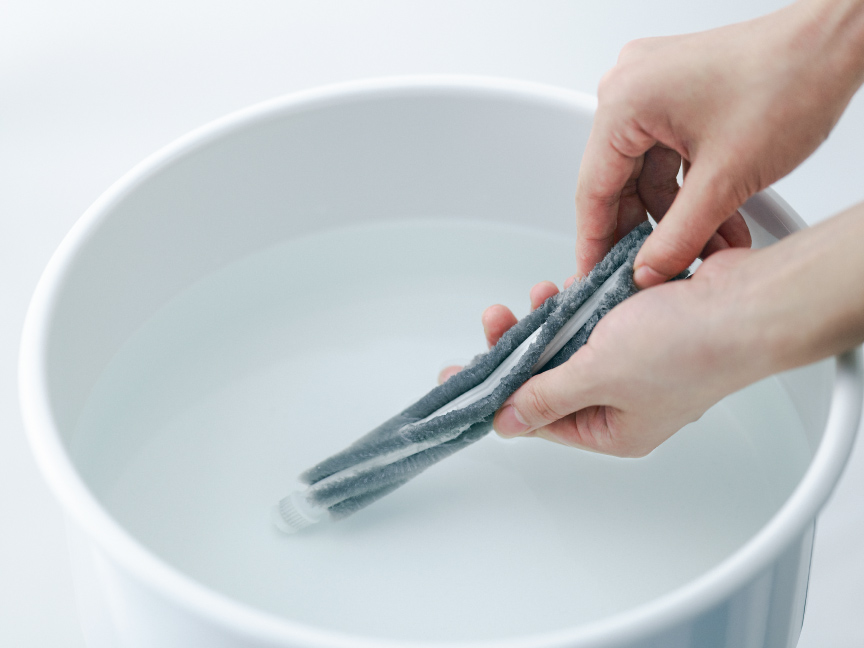 写真：ブラシを水洗いする様子