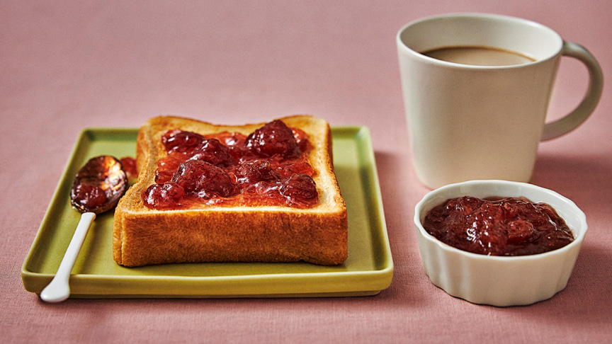 写真：トーストとジャムと飲み物が入ったマグカップ