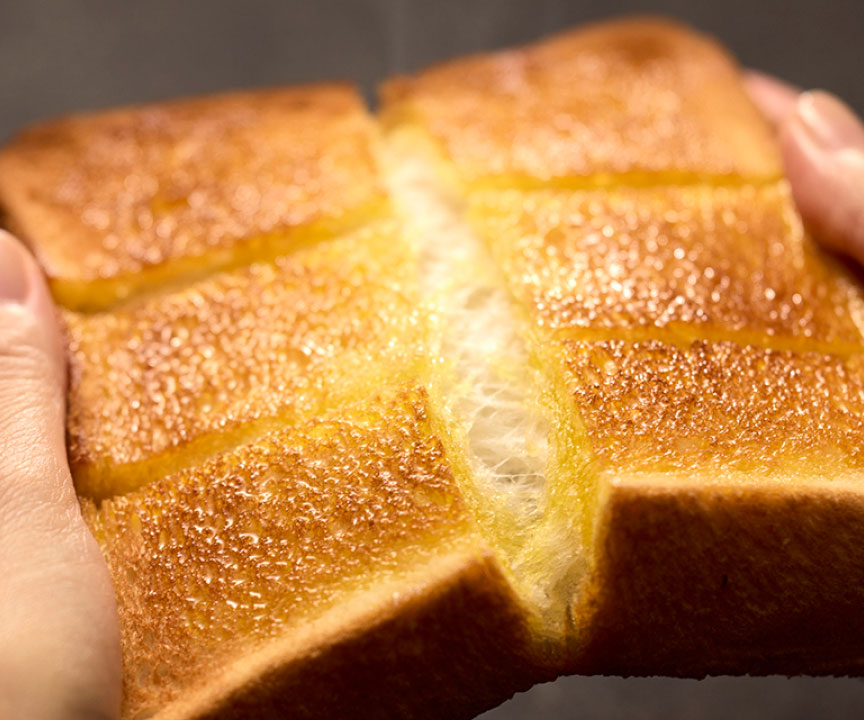 写真：切り込みを入れたトーストを割るようす