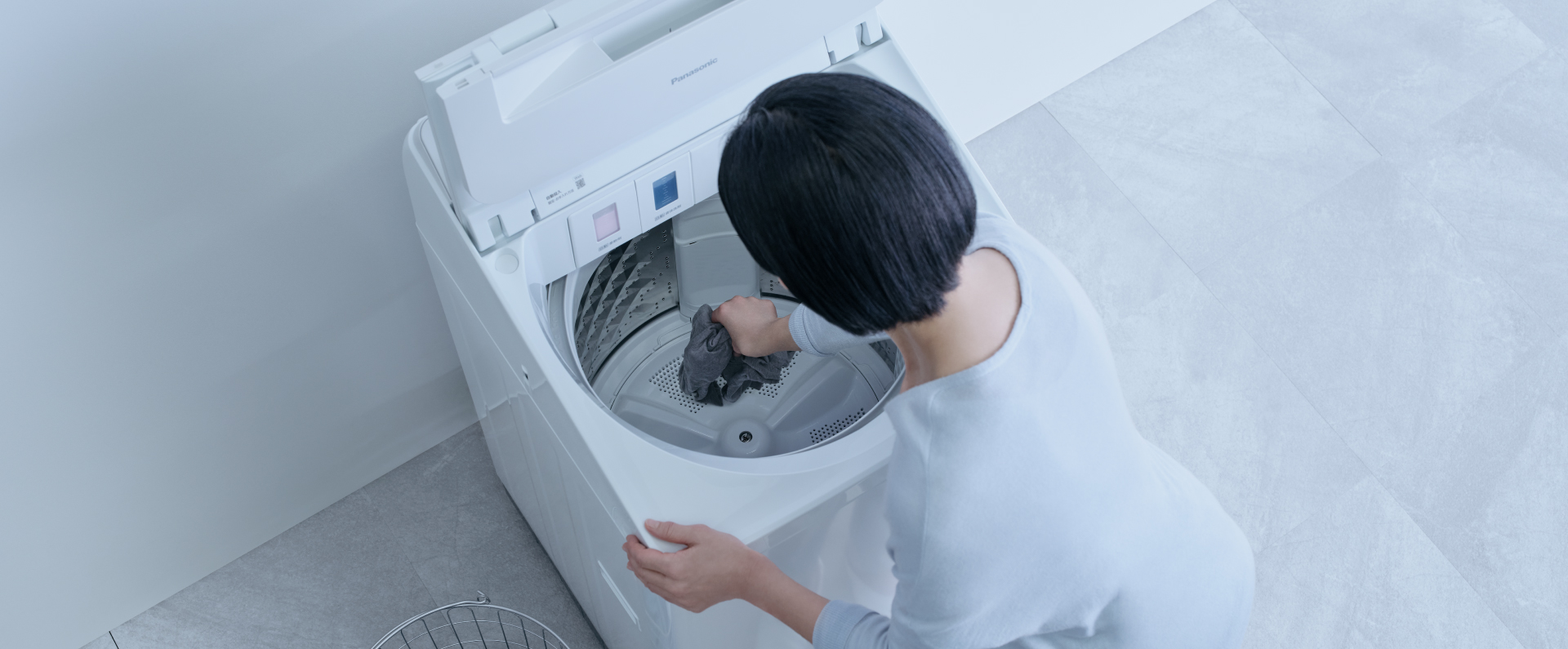 洗濯槽の底の衣類を取り出しているイメージ