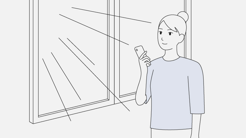スマホを片手に、窓際で陽の光を浴びている女性のイラストです。