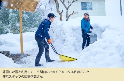 除雪した雪を利用して、玄関前にかまくらを作る佐藤さんと、運営スタッフの飯野正義さん。