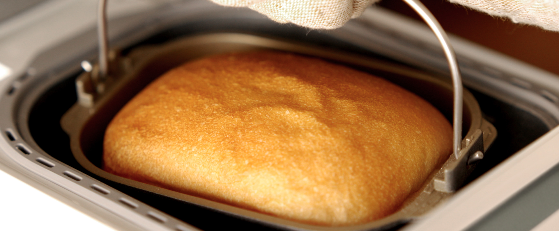 写真：焼きあがったパンが入ったパンケースを持つようす