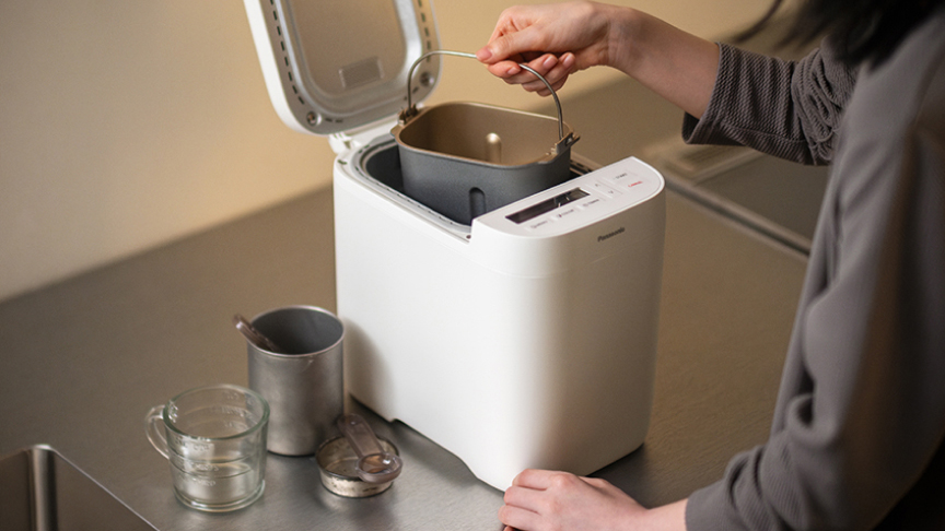 写真：ホームベーカリーに材料をセットするようす