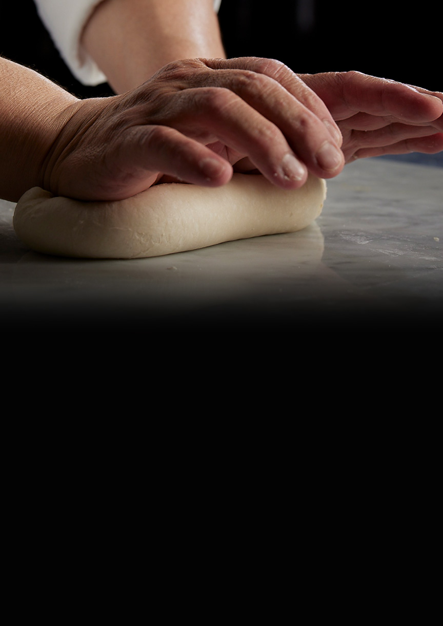 写真：職人が手でパン生地をねる様子