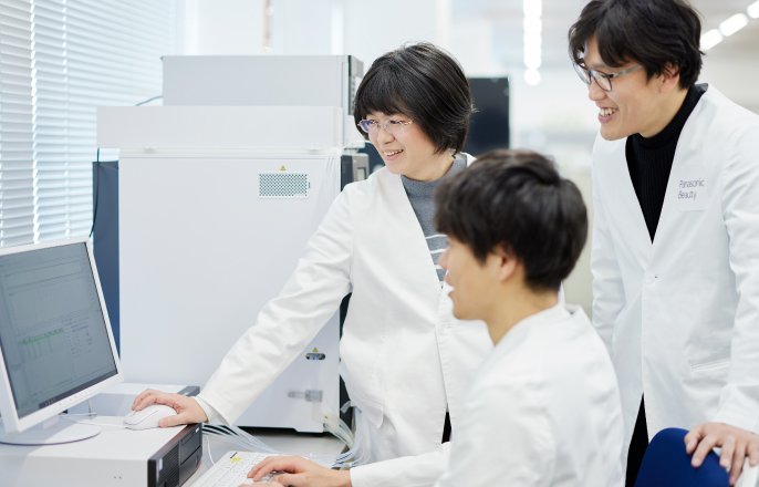 写真：パソコンの画面を見る山崎雅子さんと2人の白衣を着た男性