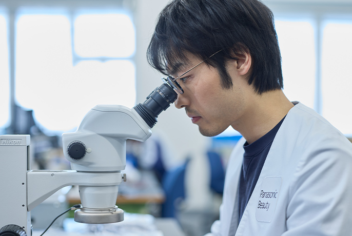 写真：顕微鏡を覗いている坂本滉大さん
