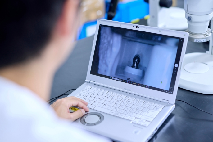 ノートパソコンの画面で拡大映像を確認しながら作業している様子