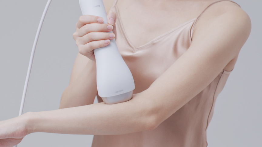 写真： 電源を入れ、肌に密着させ垂直にあてるイメージ