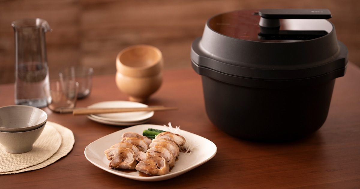 写真：調理済みの肉料理とオートクッカーが並ぶキッチン