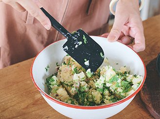 写真：足したい材料を入れてポテトサラダをまぜる