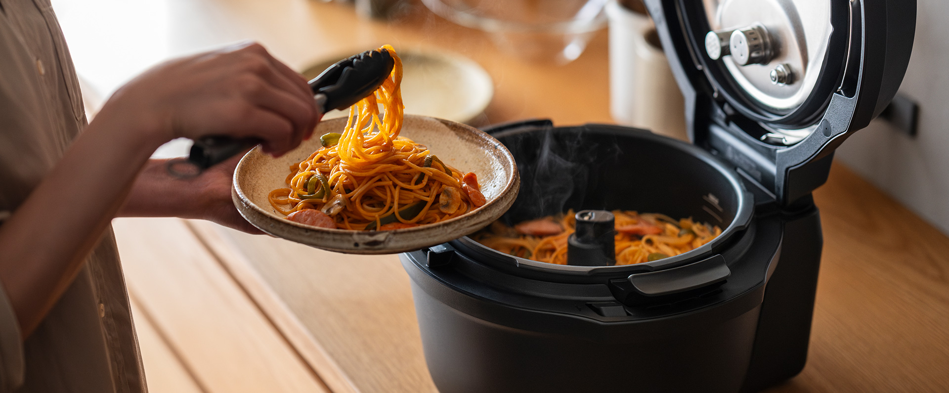 写真：パスタをトングで掴むようす