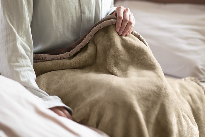 写真：電気毛布を触っているイメージ