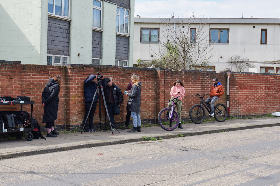 『BIKES』の撮影中、小編成の撮影クルーが道端でプレイバックを確認。