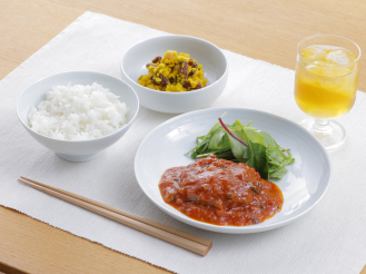 盛り付け例：白米、ソースがかかったメイン料理と付け合わせ、小鉢、飲み物