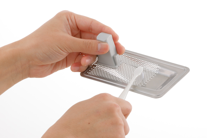 イメージ写真：残さいフィルターの汚れをブラシでこすり落とす様子