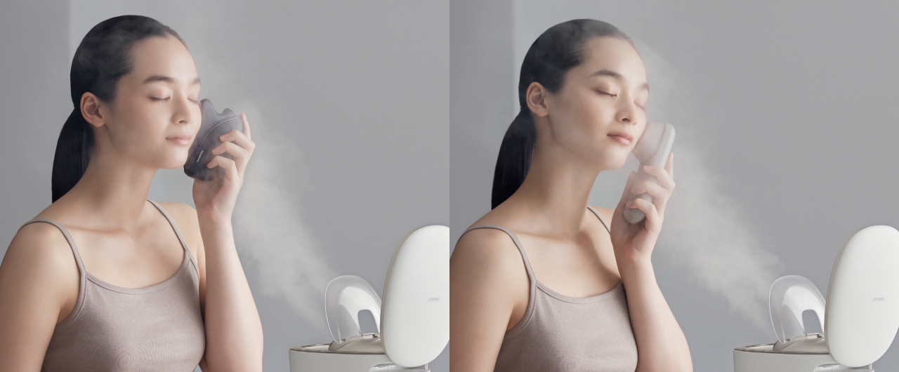 写真：スチームを浴びながら美顔器でケアする女性