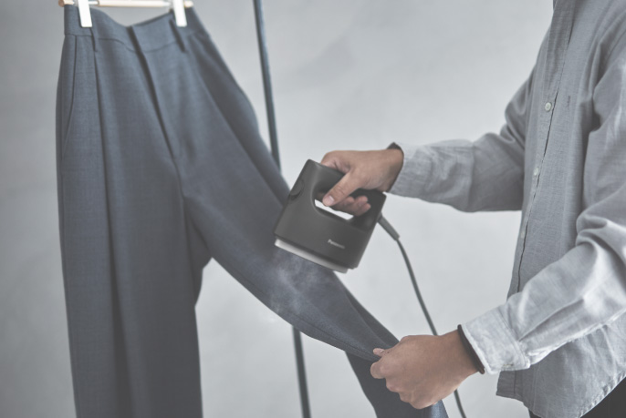 イメージ：アイロン台なしでズボンに衣類スチーマーをあてる様子