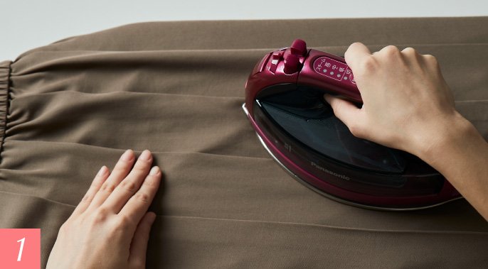 プリーツを整え、すそをアイロンで押さえる