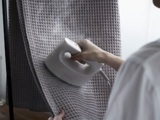 ［写真］衣類スチーマーでブランケットをケアしている様子