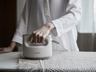 ［写真］衣類スチーマーでラグをケアしている様子