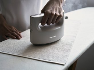 ［写真］衣類スチーマーでランチョンマットをプレス仕上げしている様子