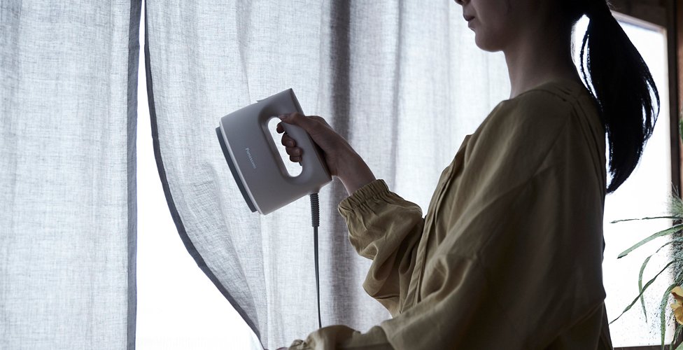 カーテンを衣類スチーマーでケアする様子