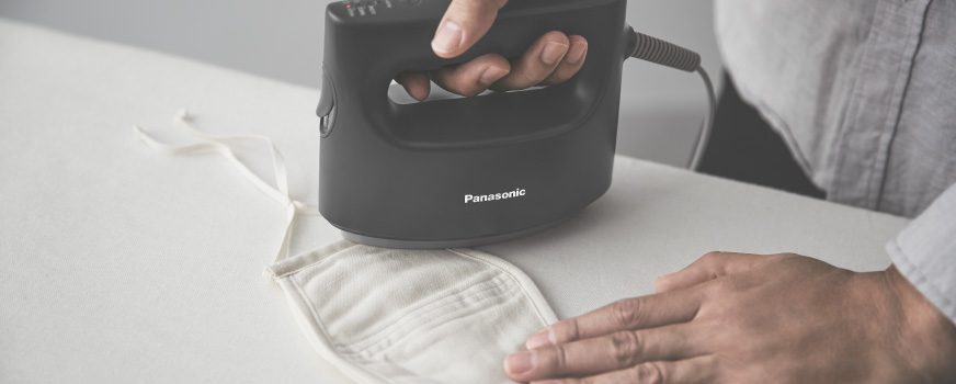 マスクを衣類スチーマーでプレスする様子