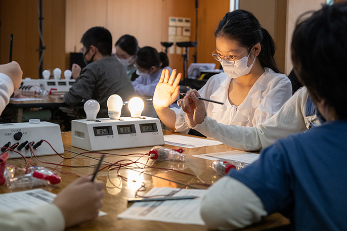 写真：消費電力計を使って消費電力の違いを実験