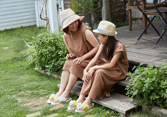 写真：帽子をかぶって庭で過ごす親子