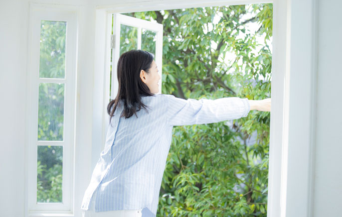 写真：窓を開ける女性のイメージ