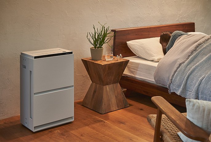 写真：ベッド脇に加湿空気清浄機を設置している様子