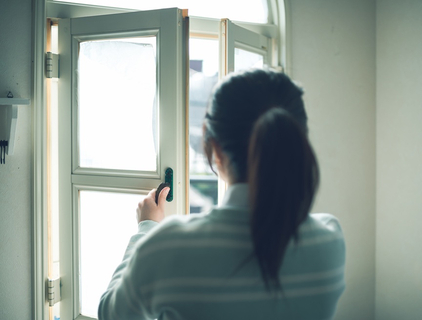 写真：窓を開ける女性