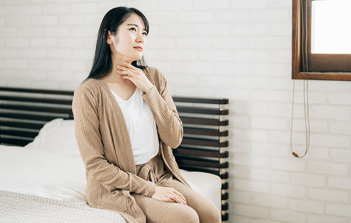 写真：喉をおさえる女性