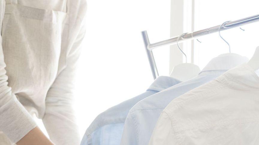 ハンガーラックにかかった服と人物の写真